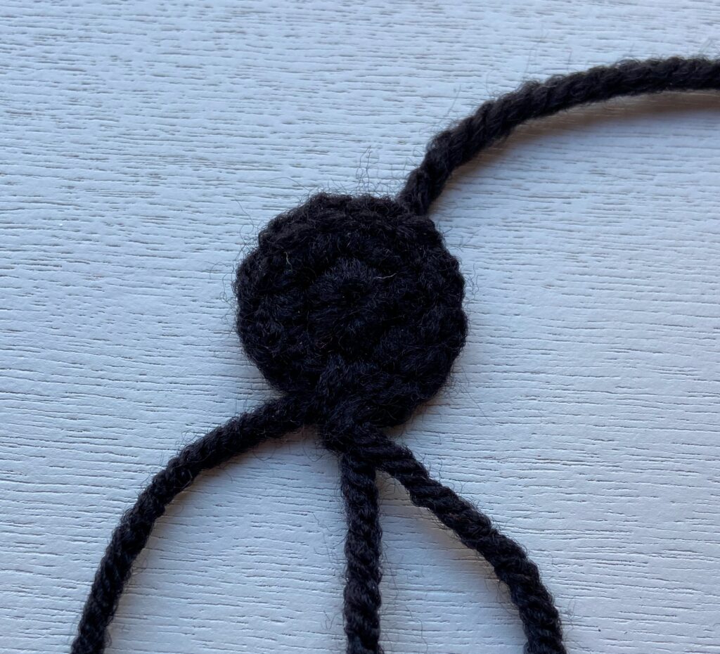 Middle black part of the mouth. It is a black circle with two rows of stitches.